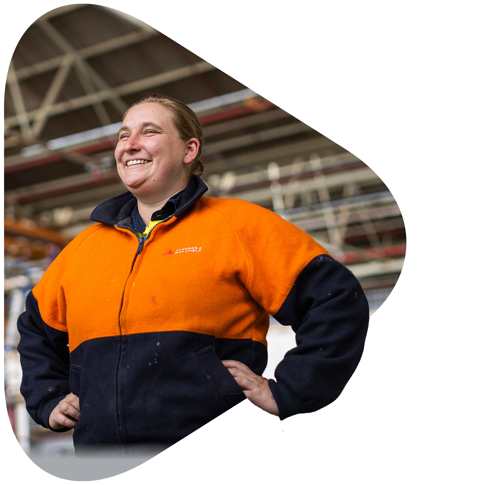 A mature aged female construction apprentice standing onsite smiling with hands on hips