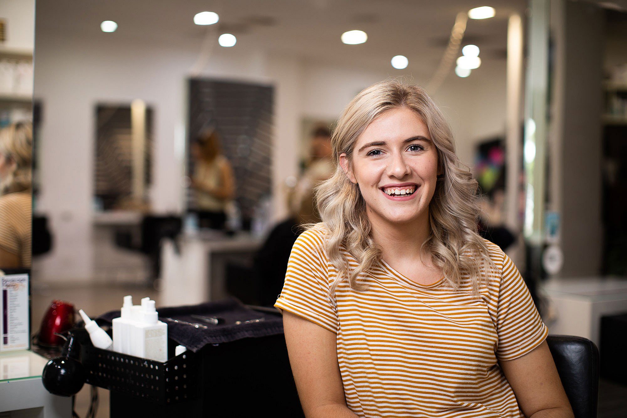 Young female apprentice hairdresser at hair salon in South Australia